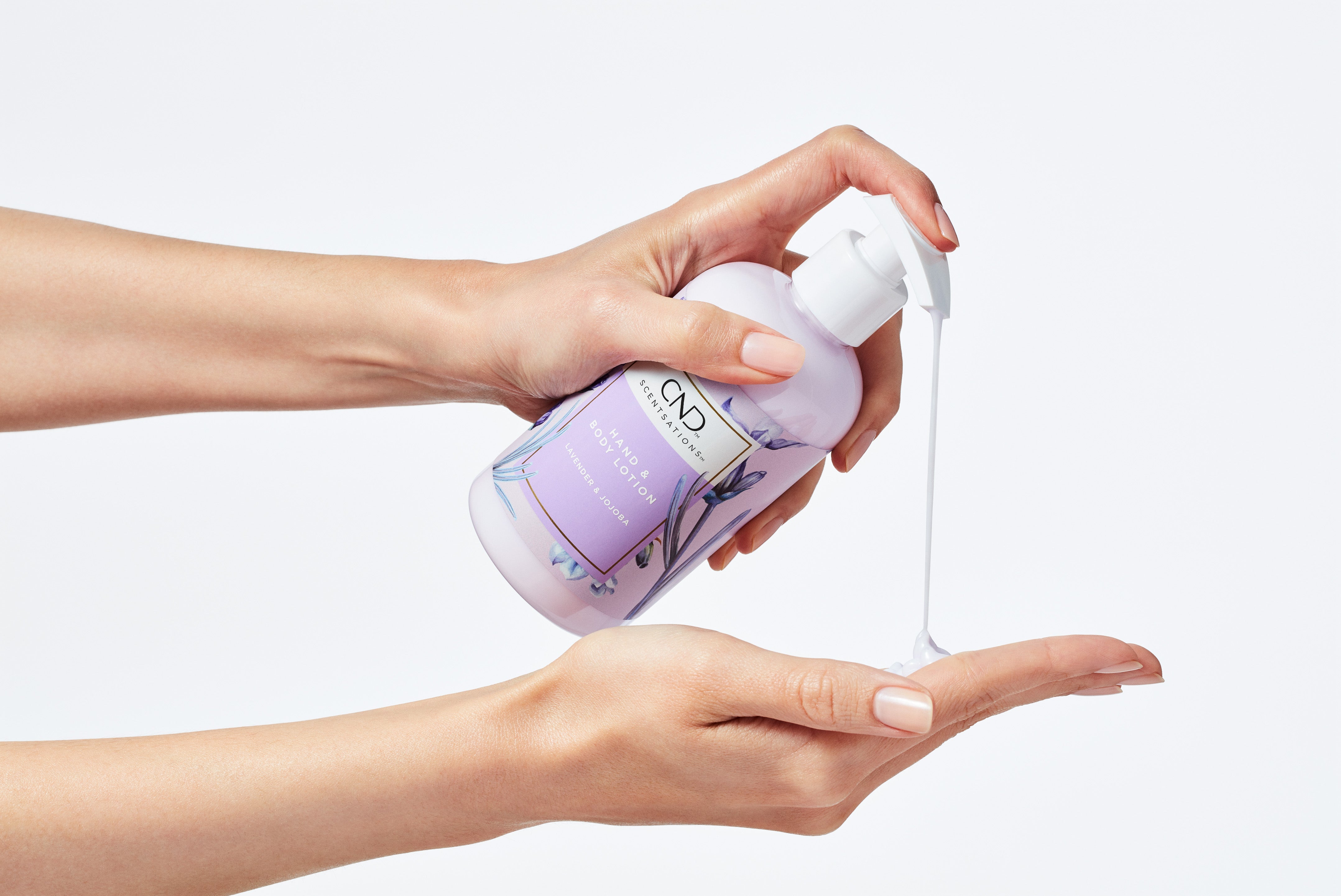 Two hands with a hand and body lotion pump bottle dispensing lotion