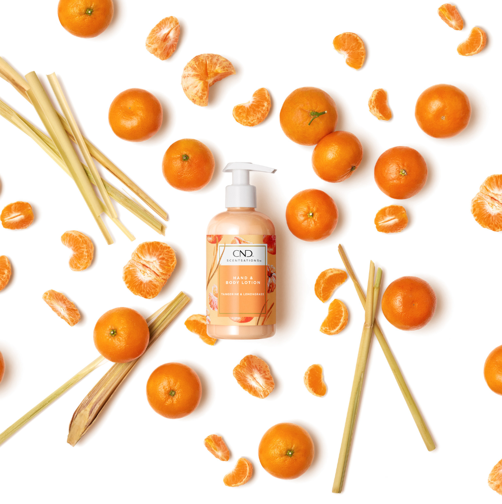 Single pump bottle of body lotion, on a background of tangerines and lemongrass.