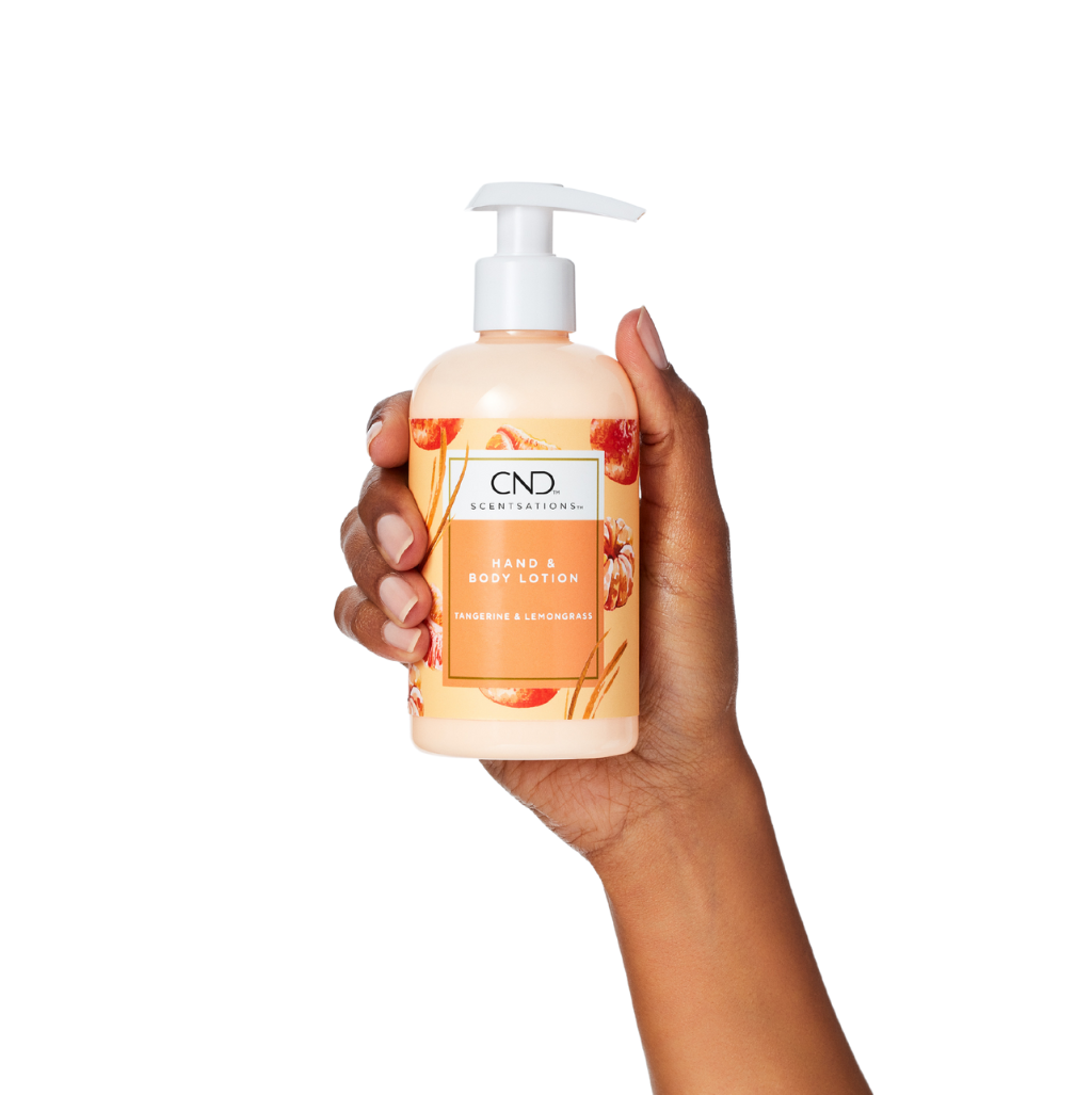 Hand holding a plastic pump bottle, orange label.